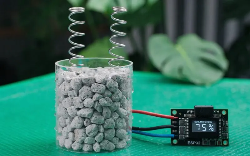 Capacitive soil moisture sensor connected to an ESP32 development board with LCD moisture readings